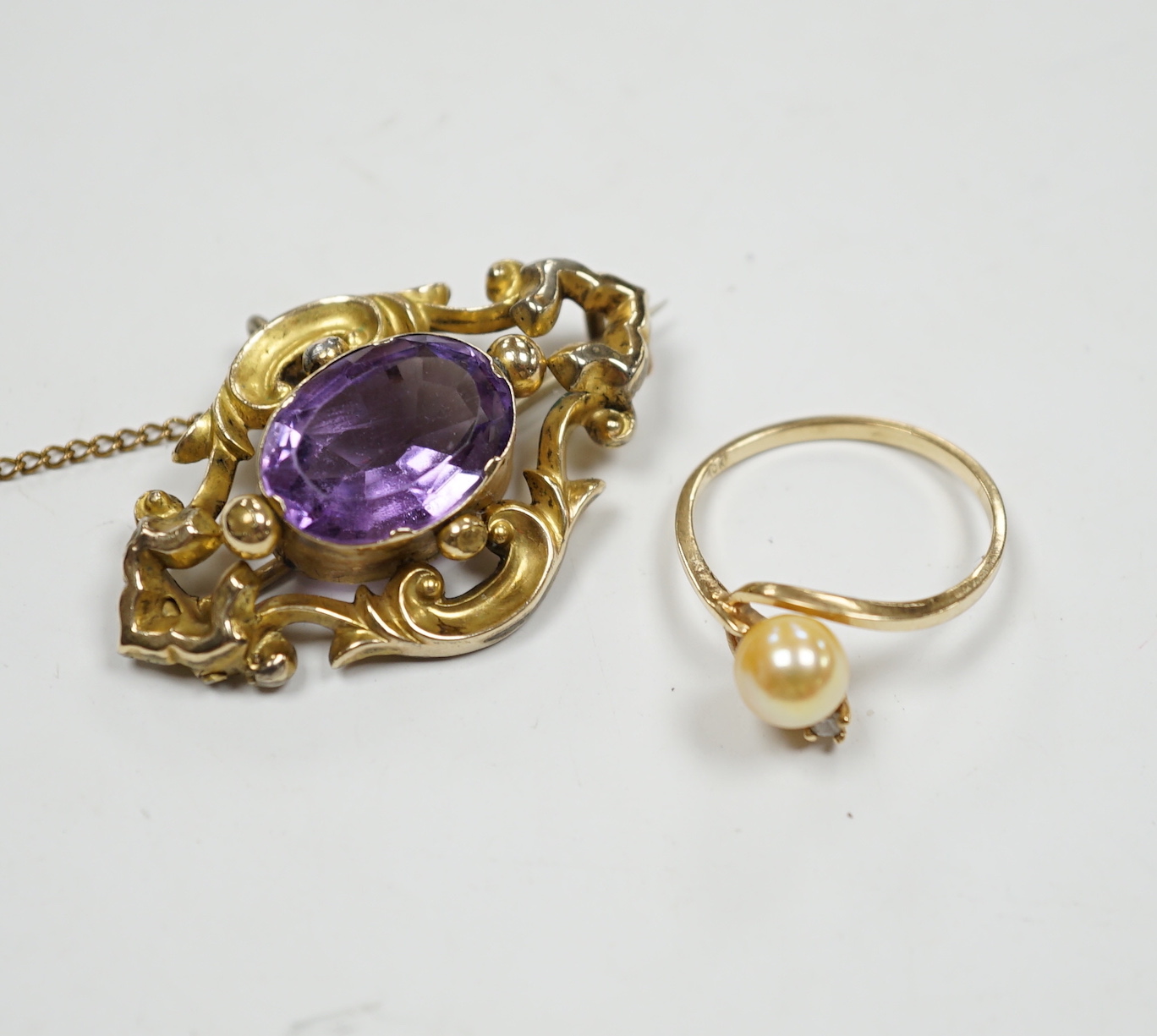 A late Victorian yellow metal mounted amethyst brooch, 38mm pendant and a 10k, cultured pearl and diamond set two stone ring.